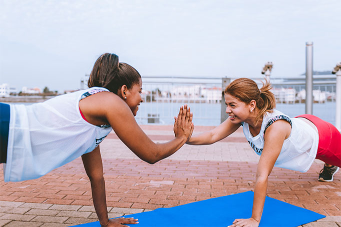 women doing push ups and high fiving