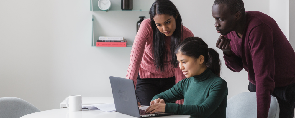group of workers looking at computer in office